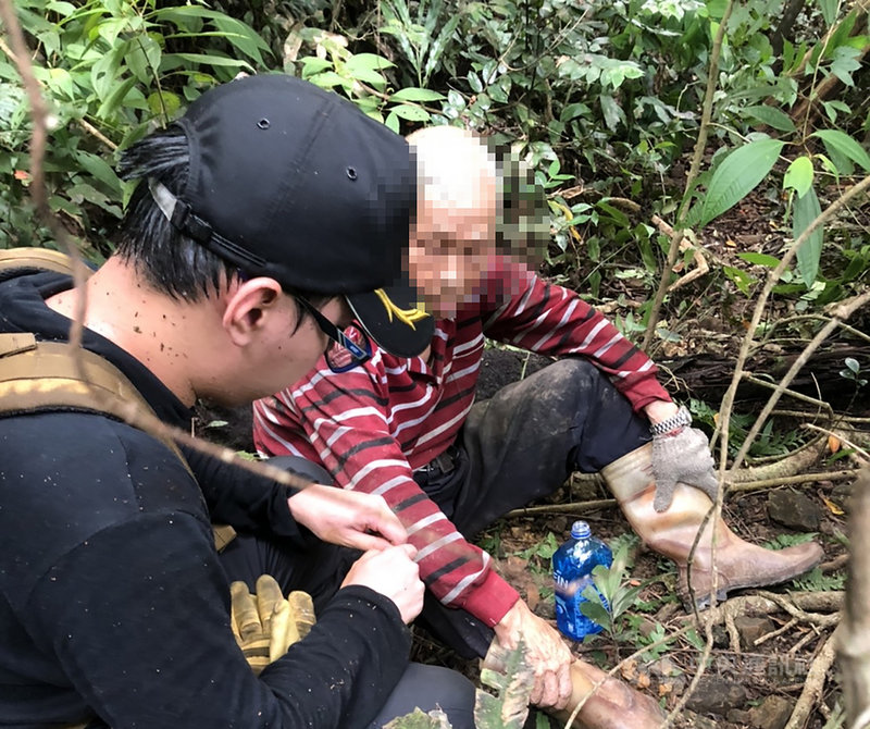 80歲謝姓男子26日上午與妻子到基隆市暖暖區東勢街山區採竹筍失蹤逾30小時,搜救人員27日下午3時發現謝男身影,由於尋獲地點附近地勢陡峭,搜救人員須開路後才能協助將謝男帶離現場就醫。(讀者提供)中央社記者王朝鈺傳真 109年7月27日