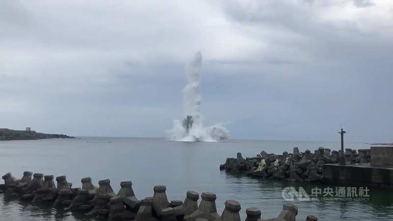 新北市貢寮區卯澳灣海中日前發現13顆未爆彈,軍方30日上午完成前置作業後,在岸上以遙控器引爆,現場海域濺起巨大高聳水花。(讀者提供)中央社記者王朝鈺傳真 109年7月30日
