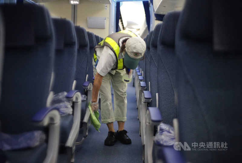 全日空航空(ANA)3日起每週一及每週五使用波音787-8客機復飛松山羽田航線,中午班機抵達松山機場後,地勤人員進入機艙清潔,加強餐桌、扶手等旅客觸碰部位的消毒。中央社記者裴禛攝 109年8月3日