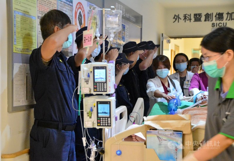 新北市警員楊庭豪4日器官移植,下午約2時許,躺在病床上的楊庭豪從5樓被推出,員警列隊敬禮並獻花,說出「謝謝你的大愛」。中央社記者黃旭昇新北攝 109年8月4日