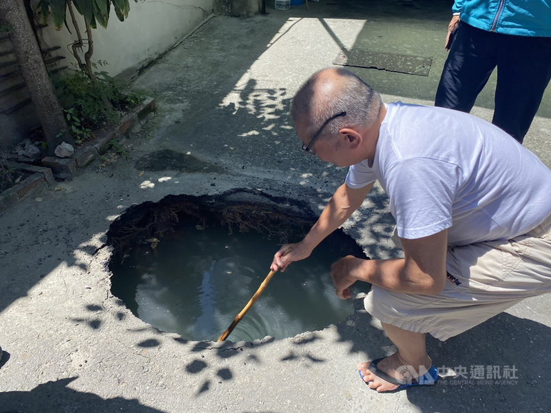 彰化縣彰化市中興路186巷的道路6日上午突然出現一個坑洞,附近民眾拿竹竿測試,發現坑洞深約1公尺。由於附近有興建大樓工地,施工單位已先回填水泥,穩固地基。(翻攝畫面)中央社記者吳哲豪傳真 109年8月6日