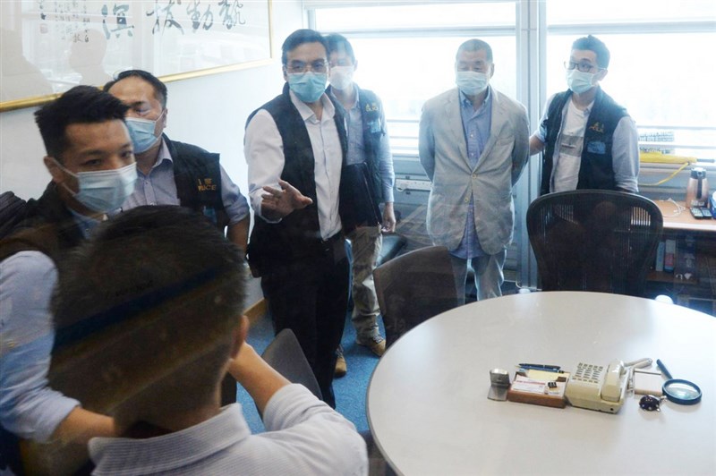 香港傳媒大亨黎智英(右2)被扣上手銬,押送到蘋果日報大樓內協助查證。(讀者提供)中央社記者張謙香港傳真 109年8月10日