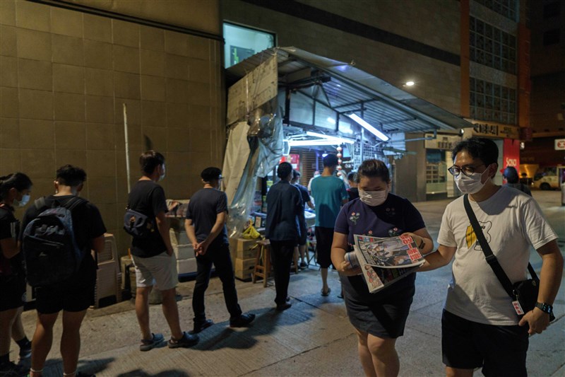 香港蘋果日報11日如常發行,加印至55萬份,旺角一處報攤一早就出現購買人龍。(法新社)