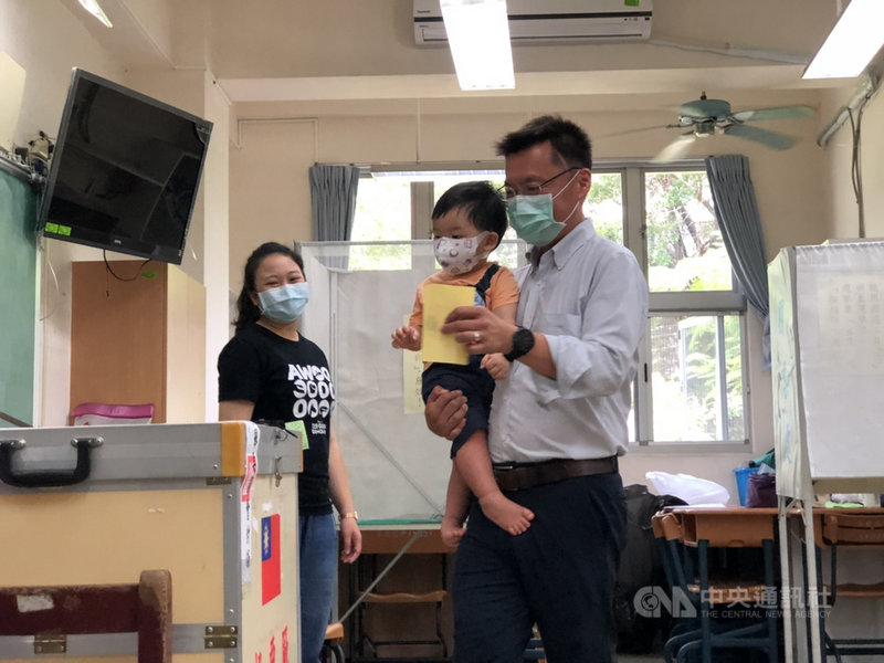 民進黨立委趙天麟(右)15日到苓雅國中投票,他一手抱著小兒子、一手投蓋選票,格外受到關注。他說,這是機會教育、民主教育的一環。(趙天麟立委辦公室提供)中央社記者王淑芬傳真 109年8月15日