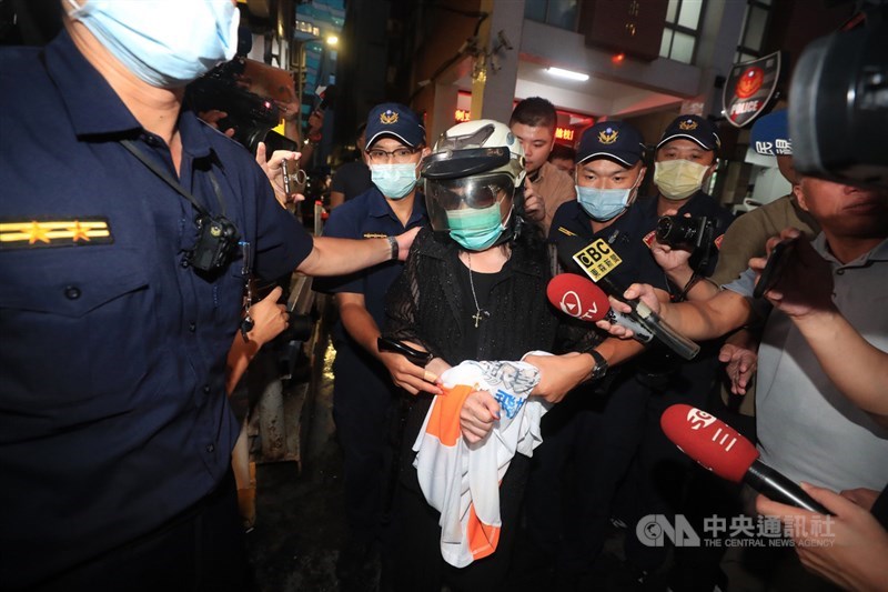 資深藝人鄭惠中(中)14日赴位於台北賓館的已故前總統李登輝追思會場,朝李登輝照片潑灑紅漆,警方獲報到場將她帶回問訊,晚間移送。中央社記者吳家昇攝 109年8月14日