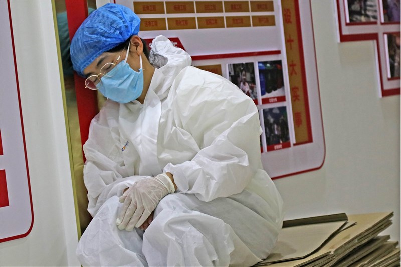 中國目前現有確診病例655例,累計死亡病例4634例,累計報告確診病例8萬4808例。圖為新疆烏魯木齊醫護人員靠著牆壁休息。(中新社)
