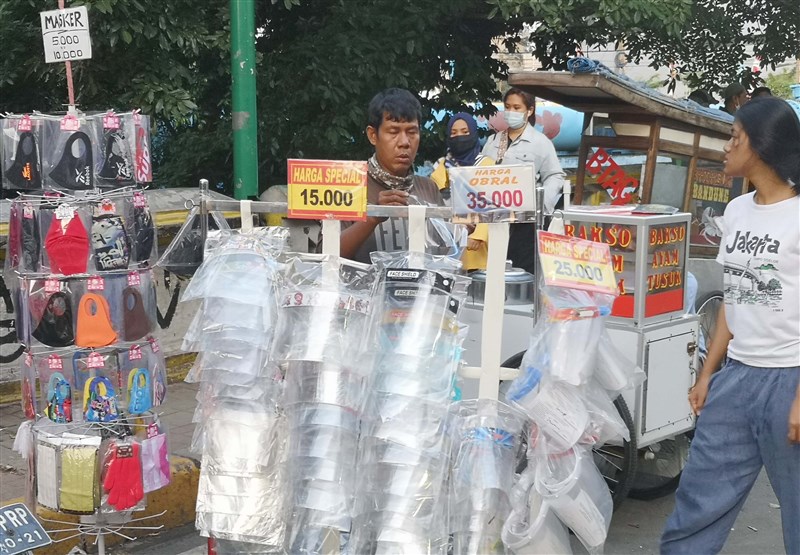 印尼武漢肺炎不治死亡人數達6418人,是東南亞國家中染疫死亡數最高的國家。圖為印尼雅加達販賣口罩和防疫面罩的路邊攤販。(中新社)