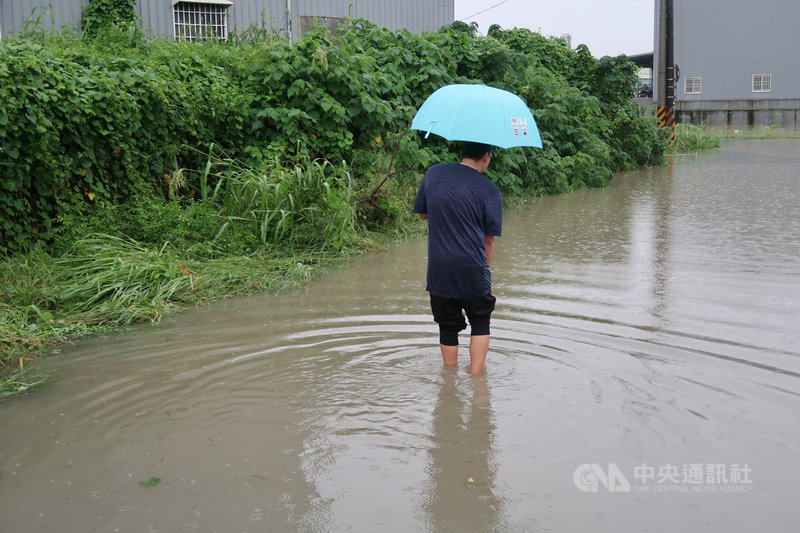 高雄市26日清晨起有間歇性豪雨伴隨落雷,岡山嘉興里一帶排水不良,五甲尾排水已近滿水位,河岸道路積水,民眾涉水難行。中央社記者王淑芬攝 109年8月26日