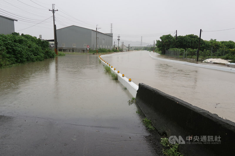 高雄市26日清晨下起大雷雨,豪雨造成市區多處積水,嘉興里五甲尾排水溝近滿水位,河水溢流到便道,人車難行。中央社記者王淑芬攝 109年8月26日