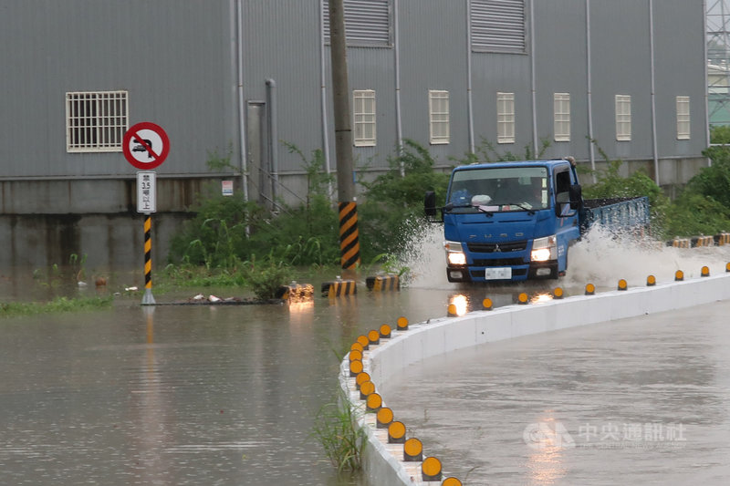 高雄市岡山區五甲尾排水溝26日因豪雨不斷已近滿水位,河水溢流到便道,造成附近人車通行困難。中央社記者王淑芬攝 109年8月26日