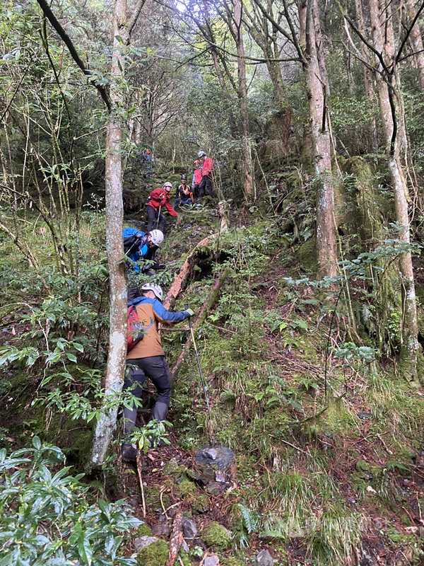 一名趙姓女子日前攀登中雪山失聯多日,一名苗栗縣消防局特搜隊員26日進行搜救時,在山區步道不慎滑落10公尺深陡坡,手腕骨折,後以直升機吊掛救援送醫。(苗栗縣消防局提供)中央社記者管瑞平傳真 109年8月26日