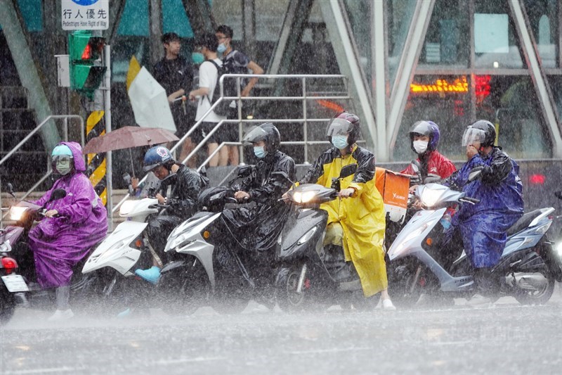 西南風影響及對流雲系發展旺盛,中央氣象局27日對北北基、台南市、高雄市及屏東縣6縣市發布豪雨特報,午後台北雨勢傾盆,機車族雨中等待信號燈轉換。中央社記者孫仲達攝 109年8月27日