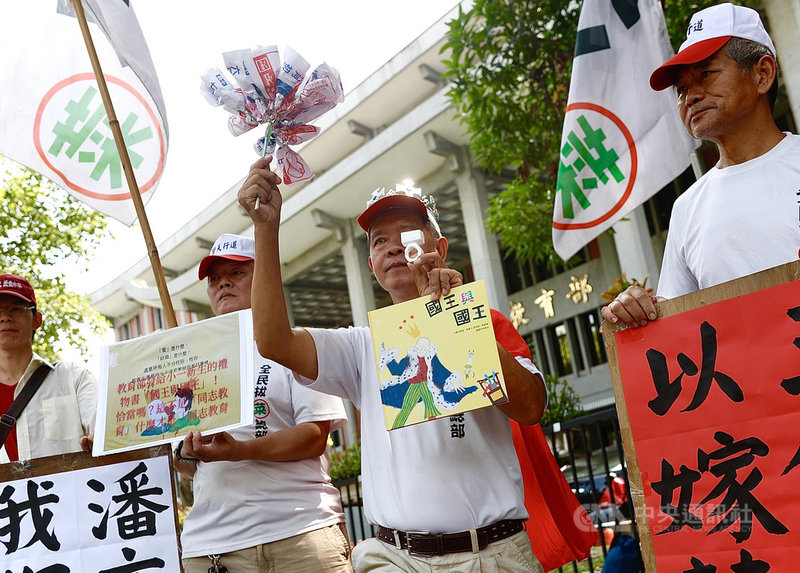 全民拔菜總部8日在教育部門前抗議,反對將書籍「國王與國王」發給小學生。拔菜總司令盧朝財(右2)打扮成國王,以道具戒指向教育部長潘文忠求婚,並大喊「我暗戀你好久了」。中央社實習記者曾守一攝 109年9月8日