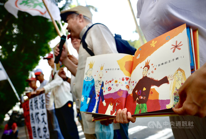 民間團體「全民拔菜總部」8日到教育部門口前,展示教育部贈送給國小新生的書籍「國王與國王」,指內容誤導學生理解兩性關係及性傾向。中央社實習記者曾守一攝 109年9月8日