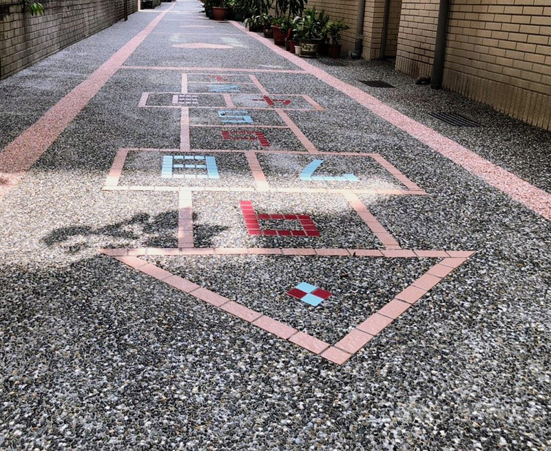 台北市政府工務局衛生下水道工程處自民國89年起,在污水接管同時協助美化後巷地坪,至今年已完成2020條後巷美化,其中,在大安區光武里以洗石子鋪面上加入遊戲元素,設計成跳格子的童趣圖案。(台北市工務局提供)中央社記者陳怡璇傳真 109年9月8日
