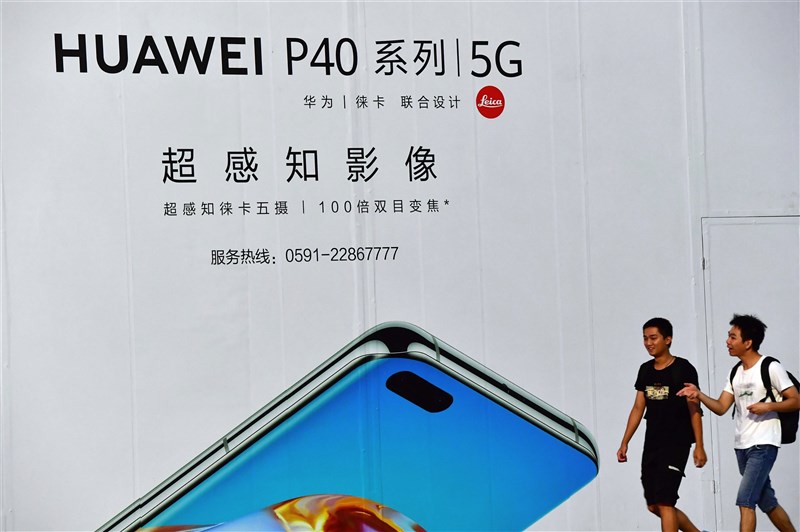 美國川普政府打擊華為技術公司,意在破除中國稱霸世界5G的野心與長遠的資訊安全疑慮。圖為福建市民從華為5G手機廣告旁經過。(中新社)