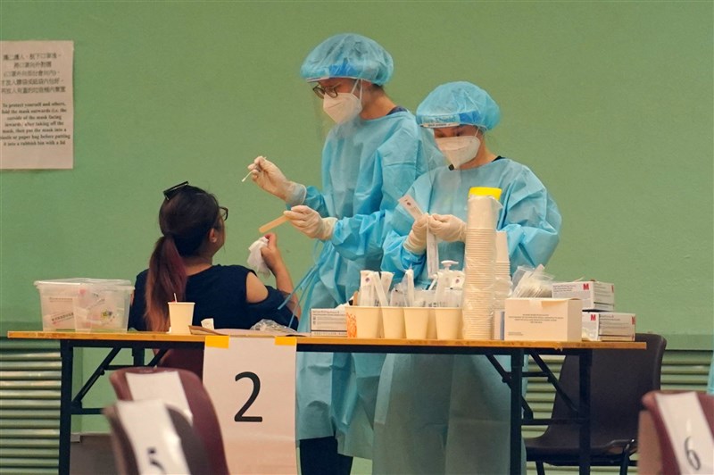 協助香港進行武漢肺炎病毒核酸檢測的中國大陸支援隊16日離港,他們總共檢測了178萬3000個樣本,發現確診病例與隱形患者共42人。圖為醫護人員採檢情形。(中新社)