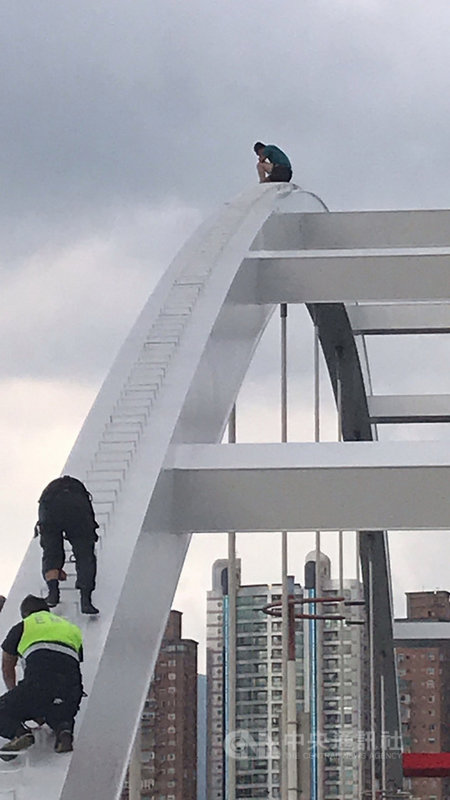 新北市八里區18日下午有1名男子不明原因爬上關渡橋頂,並企圖跳水,消防局獲報出動人車、船艇、升降機救援。(請珍惜生命。自殺防治專線(24小時):0800-788-995;生命線:1995。)(民眾提供)中央社記者黃旭昇新北傳真 109年9月18日