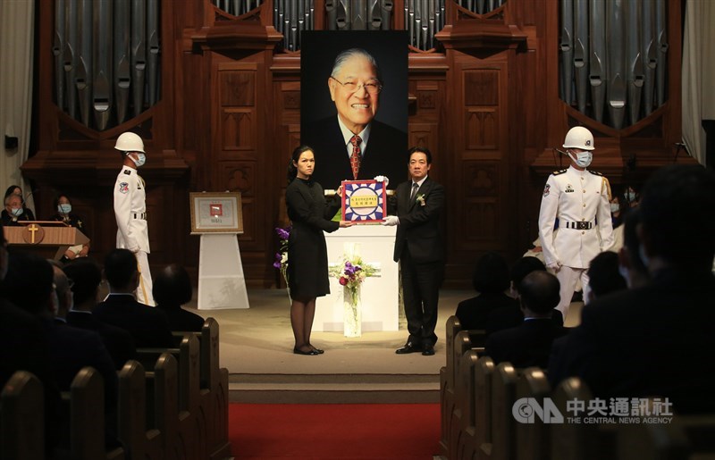 前總統李登輝追思告別禮拜19日在淡水真理大學大禮拜堂舉行,會場進行贈旗儀式,副總統賴清德(中右)致贈覆棺國旗給家屬,由孫女李坤儀(中左)代表接受。中央社記者張新偉攝 109年9月19日