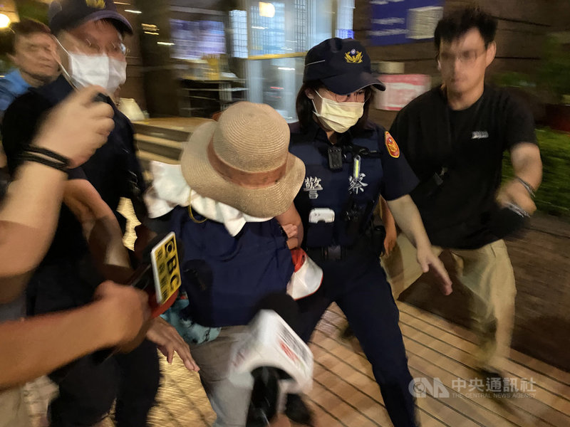 台北市內湖區康寧路一處非法私人養護所22日發生火警,造成2死1命危,警方晚間將負責人58歲丁姓女子(戴帽者)帶回偵訊,她稱出門前曾檢查、關閉屋內電源,並指其中一名男患者曾有自燒棉被情形。全案將送法辦。中央社記者黃麗芸攝 109年9月22日