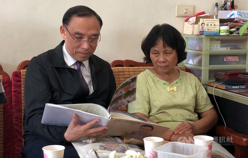 法務部長蔡清祥(左)23日慰問因公殉職鐵路警察李承翰的母親張秀珍(右),並觀看李承翰生前的相片集冊。中央社記者黃國芳攝 109年9月23日