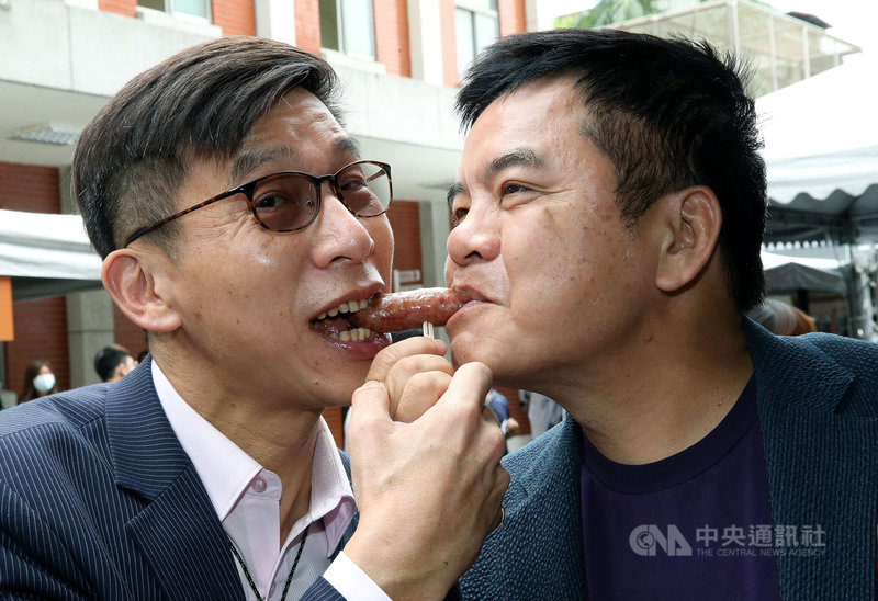 多位民進黨立委29日在立法院舉辦「我愛國產豬」美食推廣記者會,現場備有選用台灣豬肉製作的滷肉飯、烤香腸與貢丸湯三道經典夜市料理,民進黨立委鍾佳濱(左)、莊瑞雄(右)共享烤香腸好滋味。中央社記者郭日曉攝 109年9月29日