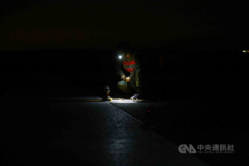 空軍日前模擬機場跑道受損進行國道一號戰備道戰機起降操演,一名地勤人員在黑夜中於國道上布設燈光設備,供起降識別。中央社記者游凱翔攝 109年10月4日