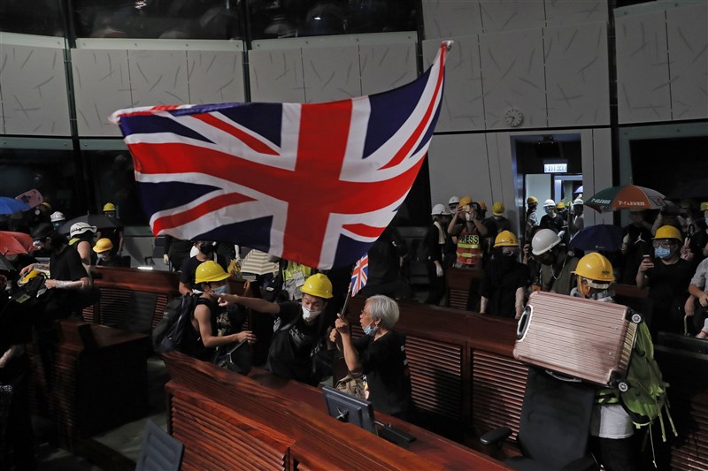 法新社報導,擁有英國海外公民身分的人,將可自31日起申請赴英生活及工作長達5年時間,且可申請成為一般公民。圖為2019年7月1日香港反送中示威闖進立法會,有人高舉英國國旗。(美聯社)