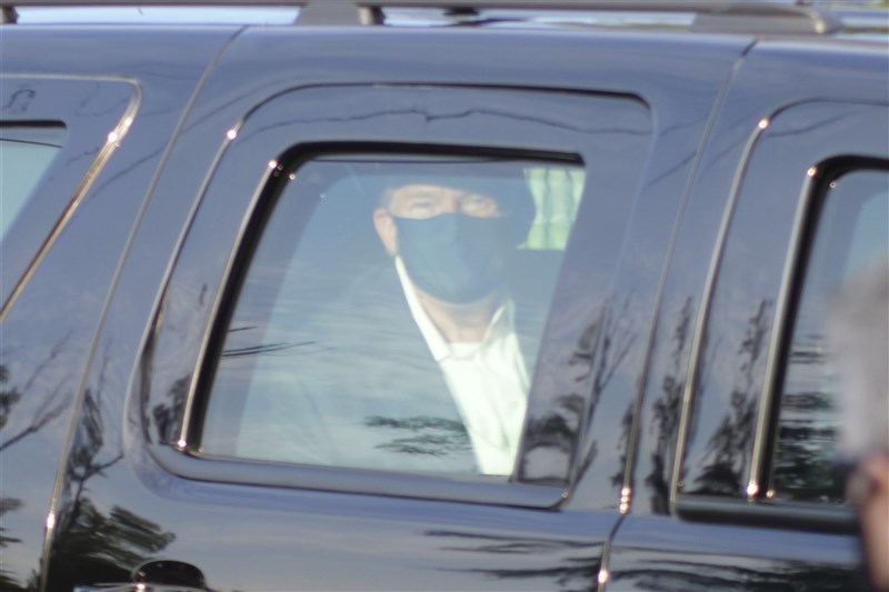 美國總統川普確診武漢肺炎,但他4日冒著風險搭車暫離醫院,在支持者面前意外亮相,想破除病重傳聞。(美聯社)