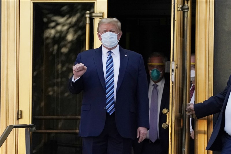 確診武漢肺炎的美國總統川普5日傍晚約6時40分左右,戴著口罩走出華特里德國家軍事醫學中心。(美聯社)