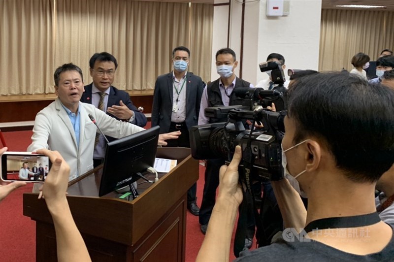 立法院經濟委員會等5委員會14日聯席審查有關含萊劑美豬牛進口行政命令,國民黨立委林為洲(左)不滿農委會陳吉仲(左2)在程序發言前就先行報告,便衝上發言台搶下麥克風。中央社記者郭建伸攝 109年10月14日