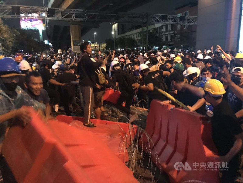 泰國示威群眾21日遊行至總理府,途中被鎮暴警察以鐵絲網架成的拒馬阻擋,但示威群眾清除部分路障後繼續遊行。中央社記者呂欣憓曼谷攝 109年10月21日