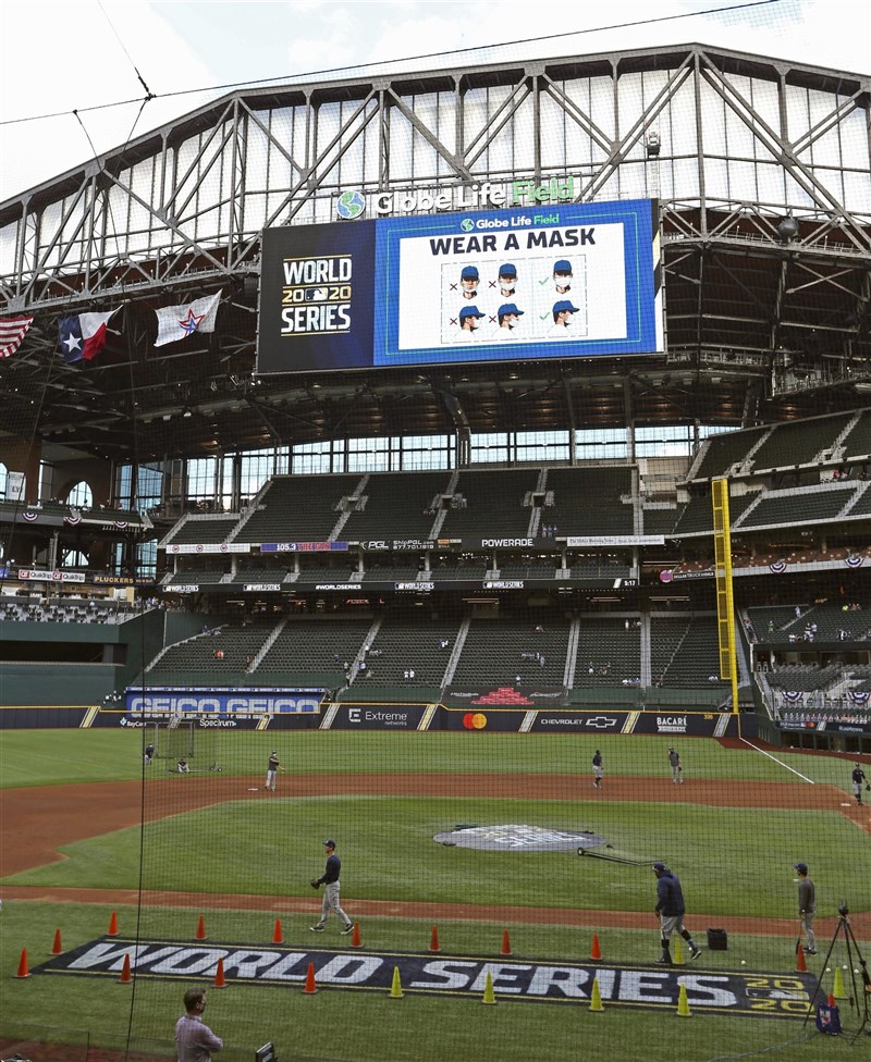 MLB世界大賽開放球迷入場,但人數嚴格管控首戰只有1萬多人進場,寫下百餘年來世界大賽觀眾最少的一次。圖為比賽場地大螢幕提醒觀眾戴口罩。(共同社)