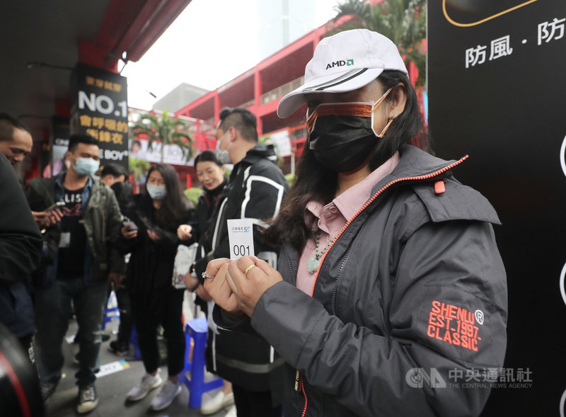 蘋果iPhone 12系列23日在台開賣,不畏低溫降雨、果粉漏夜苦等,搶得中華電頭香的客戶是從事資訊業的魏小姐(前右),上週六就來排隊,且祭出弟弟和表弟輪流幫忙的團體戰術,準備入手iPhone 12 Pro 256GB太平洋藍。中央社記者裴禛攝 109年10月23日