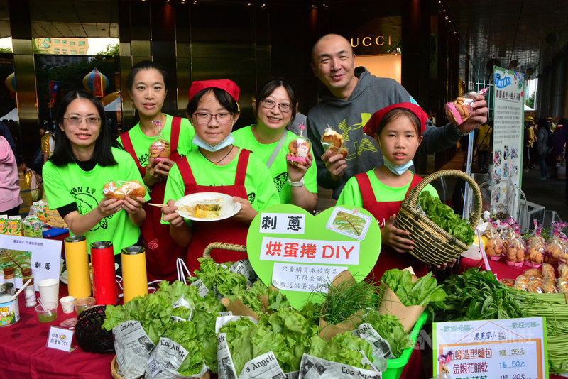 新北市教育局24日在板橋區舉辦109年度「新北小農夫市集」活動,提供孩子們實際行銷農產品的學習機會,萬里國小校長莊朝欽(後右)帶領師生到場,一起叫賣校內種植的無毒有機蔬菜。中央社記者黃旭昇新北市攝 109年10月24日