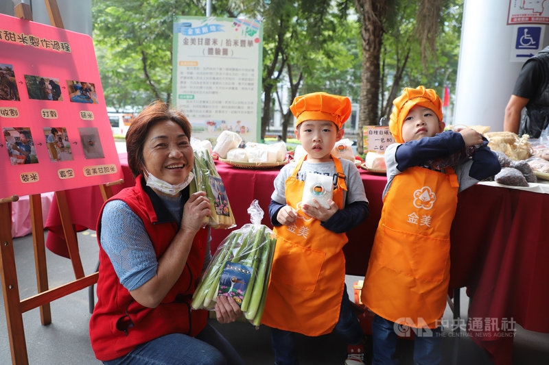 新北市小農夫市集活動24日在板橋區登場,金山區金美國小附幼學童與當地農民阿甘姨(左)一同展示特產茭白筍,及孩子們親自插秧體驗栽植的金美甘甜米,攤位並呈現校園扎根食農教育歷程。中央社記者黃旭昇新北市攝 109年10月24日
