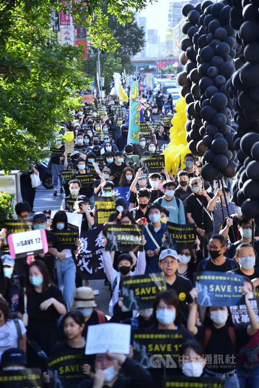 1025台灣撐港遊行25日下午在台北登場,參與民眾手持黑底黃字標語前進,不時呼喊「釋放12港人」、「光復香港、時代革命」等口號。中央社記者王飛華攝 109年10月25日