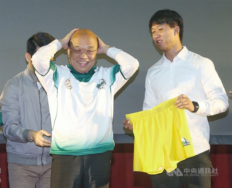行政院長蘇貞昌(前左)24日晚間在台北出席台大水牛橄欖球隊75週年慶活動,收到新球衣作為紀念,蘇貞昌現場開心套上球衣。中央社記者郭日曉攝 109年10月24日