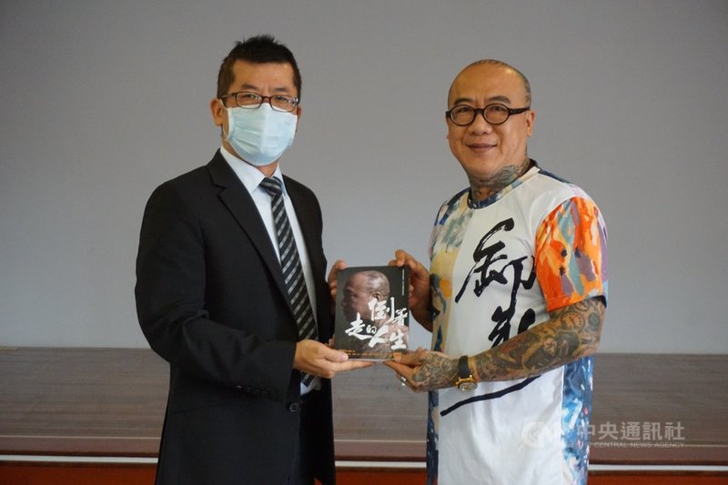 微電影「卸妝」導演顏正國28日到金門監獄演講,「卸妝」演員鋼鐵爸(阮橋本)(右)也分享走過吸毒歲月故事並致贈自傳,由典獄長楊益彰(左)代表接受。中央社記者黃慧敏攝 109年10月28日