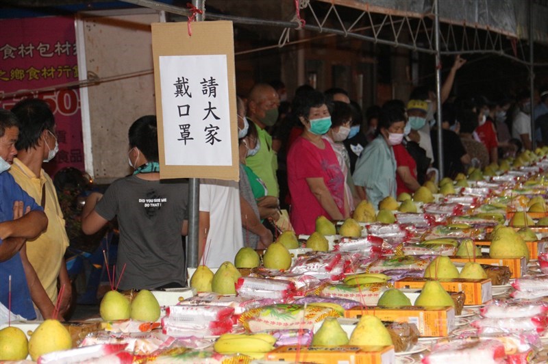 苗栗縣銅鑼鄉五福廟13日晚間舉辦普渡法會,法會圓滿結束後,開放民眾免費索取桌上供品,為響應防疫政策,廟方要求民眾戴口罩才能參與。中央社記者管瑞平攝 109年9月13日