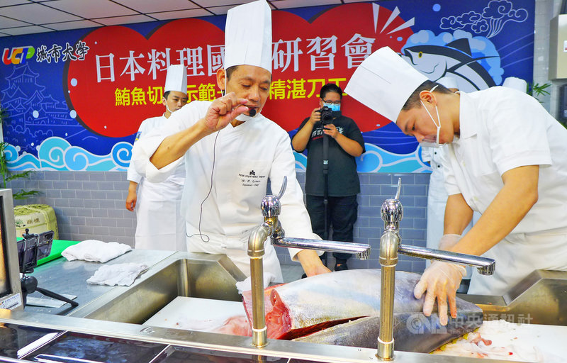 台北城市科技大學29日舉行日本料理國際研習會,邀請台北老爺酒店中山日本料理廳主廚藍文彬(前左)現場展演完整鮪魚切割示範,並指導學生練習生魚片刀工。(城市科大提供)中央社記者許秩維傳真 109年10月29日