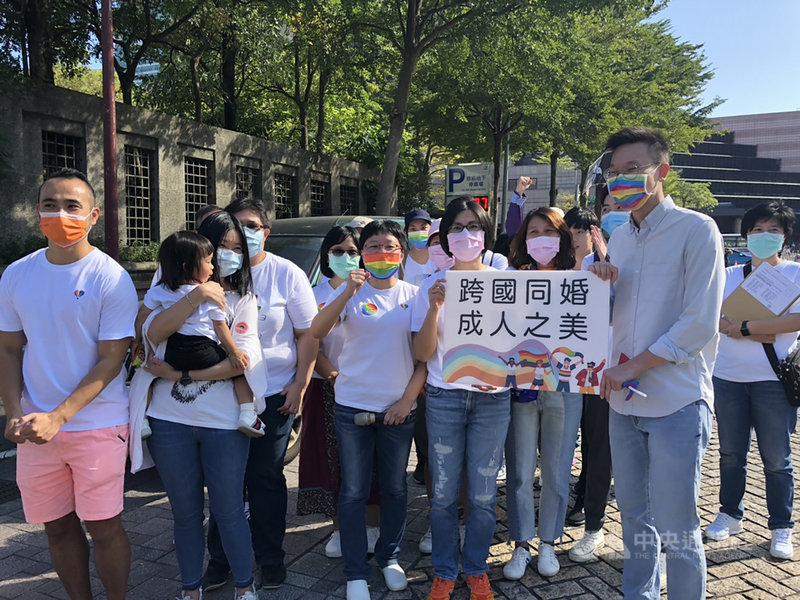 台灣伴侶權益推動聯盟與跨國同婚平權聯盟31日參與同志遊行活動,並號召逾40名跨國同性伴侶家庭,共同遞交「跨國同婚,成人之美」的陳情明信片給民進黨副秘書長林飛帆(前右),盼跨國同婚能儘速合法。(伴侶盟提供)中央社記者吳欣紜傳真 109年10月31日