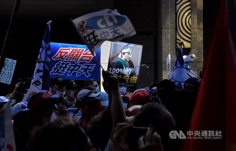 國家通訊傳播委員會(NCC)11日把過去初審使用4年的評分表格法制化與明確化,中天新聞台12日表示,換照進行中才公布評分標準不利中天,等於是考試交卷後才改配分。圖為中天支持者10月26日在場外抗議,揮舞旗幟表達「反關台挺中天」。(中央社檔案照片)