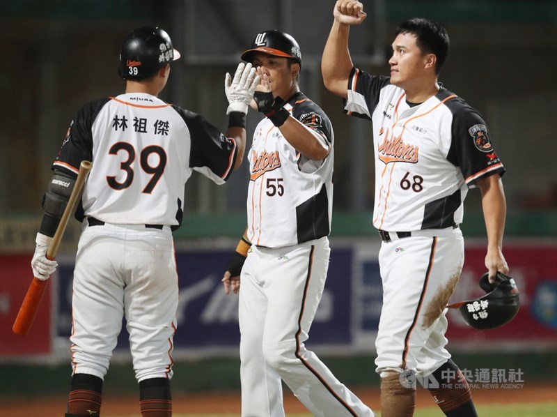 中華職棒7戰4勝制總冠軍賽(台灣大賽)第5戰繼續在台南球場舉行,5局下,統一獅隊壘上跑者潘武雄(中)、高國慶(右),靠隊友二壘安打順利回本壘得分,助隊擴大領先優勢。中央社記者張新偉攝 109年11月5日