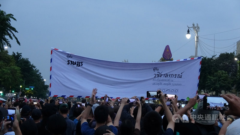泰國反政府示威人士8日傍晚從民主紀念碑前遊行至大皇宮要遞交給泰王的信,圖為模擬信件的大型布條。中央社記者呂欣憓曼谷攝 109年11月8日