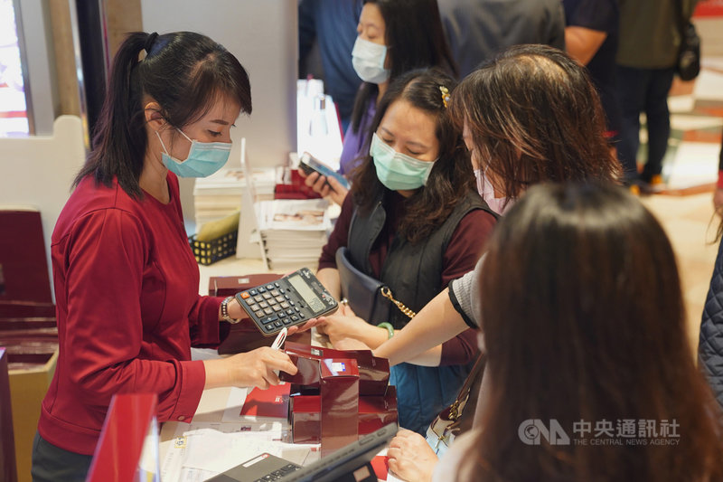 新光三越台北站前店週年慶活動12日登場,銷售人員邊按計算機邊向消費者說明優惠價格。中央社記者徐肇昌攝 109年11月12日