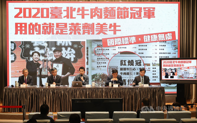 行政院發言人丁怡銘(後中)12日主持行政院會後記者會,會中秀圖表示,台北市辦的牛肉麵節,今年冠軍用的就是含有萊克多巴胺的美牛,證明只要符合聯合國食安標準,安全不會有問題。如果萊克多巴胺有問題,台北市不會由副市長親自頒獎。中央社記者謝佳璋攝 109年11月12日