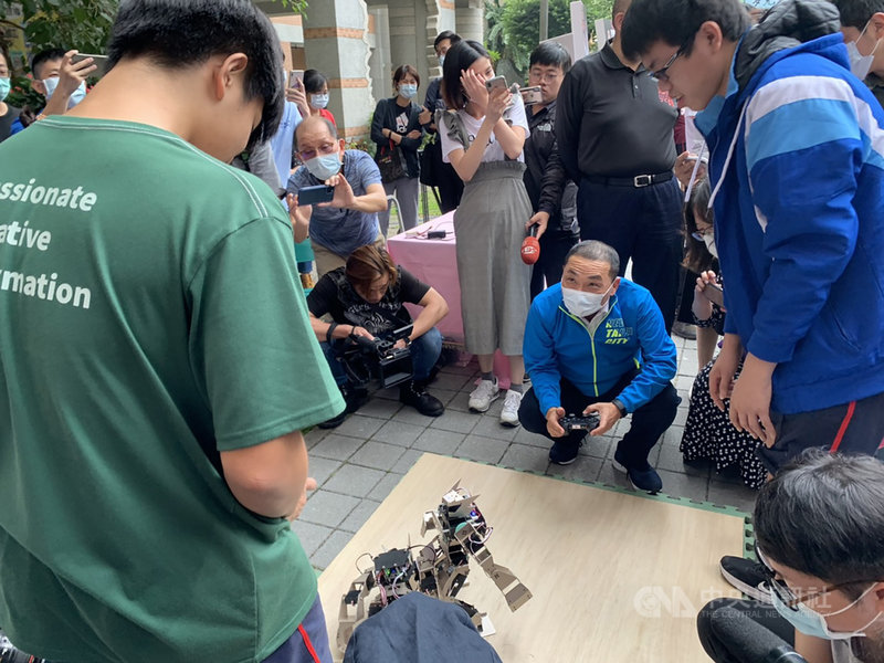 新北市長侯友宜（蹲者藍衣）20日下午到板橋高中主持主持「EMT-P+，高階救護機動支援隊」暨「CPR訓練機」發表會，會前特別和學生進行機器人格鬥賽。中央社記者沈佩瑤攝　109年11月20日