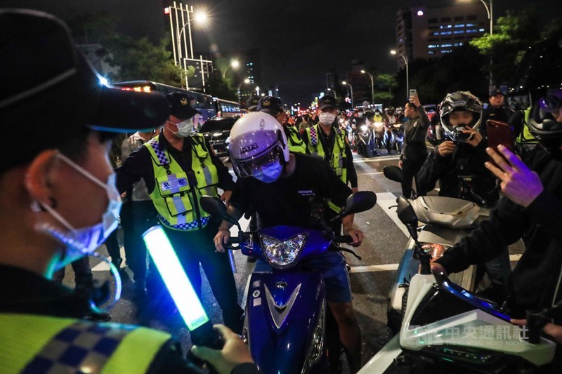 台灣機車路權促進會20日晚間號召機車族響應「待轉大富翁–全員四輪大迷航」活動,大批騎士在鄭州路與塔城街口參與,部分民眾被警方引導到路旁稽查。中央社記者吳家昇攝 109年11月20日