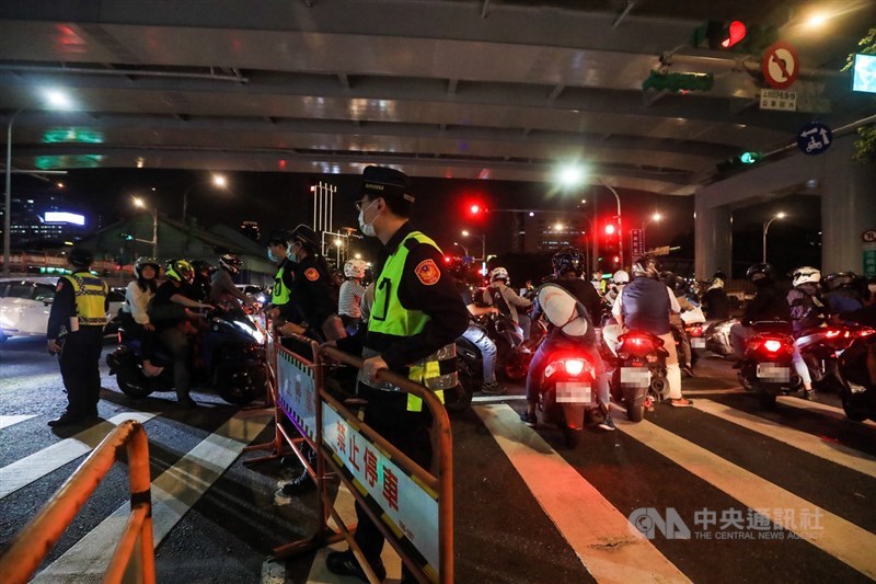 為抗議塔城街與鄭州路口強制機車兩段式左轉政策,民間團體20日晚間發起「待轉大富翁–全員四輪大迷航」活動,警方獲報到場,並設法阻擋騎士重複待轉。中央社記者吳家昇攝 109年11月20日